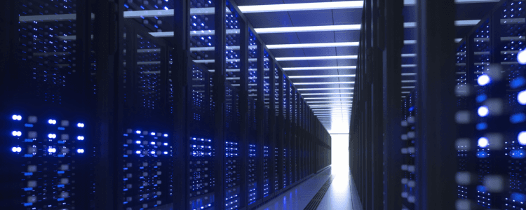 Rows of illuminated server racks running down a data centre aisle